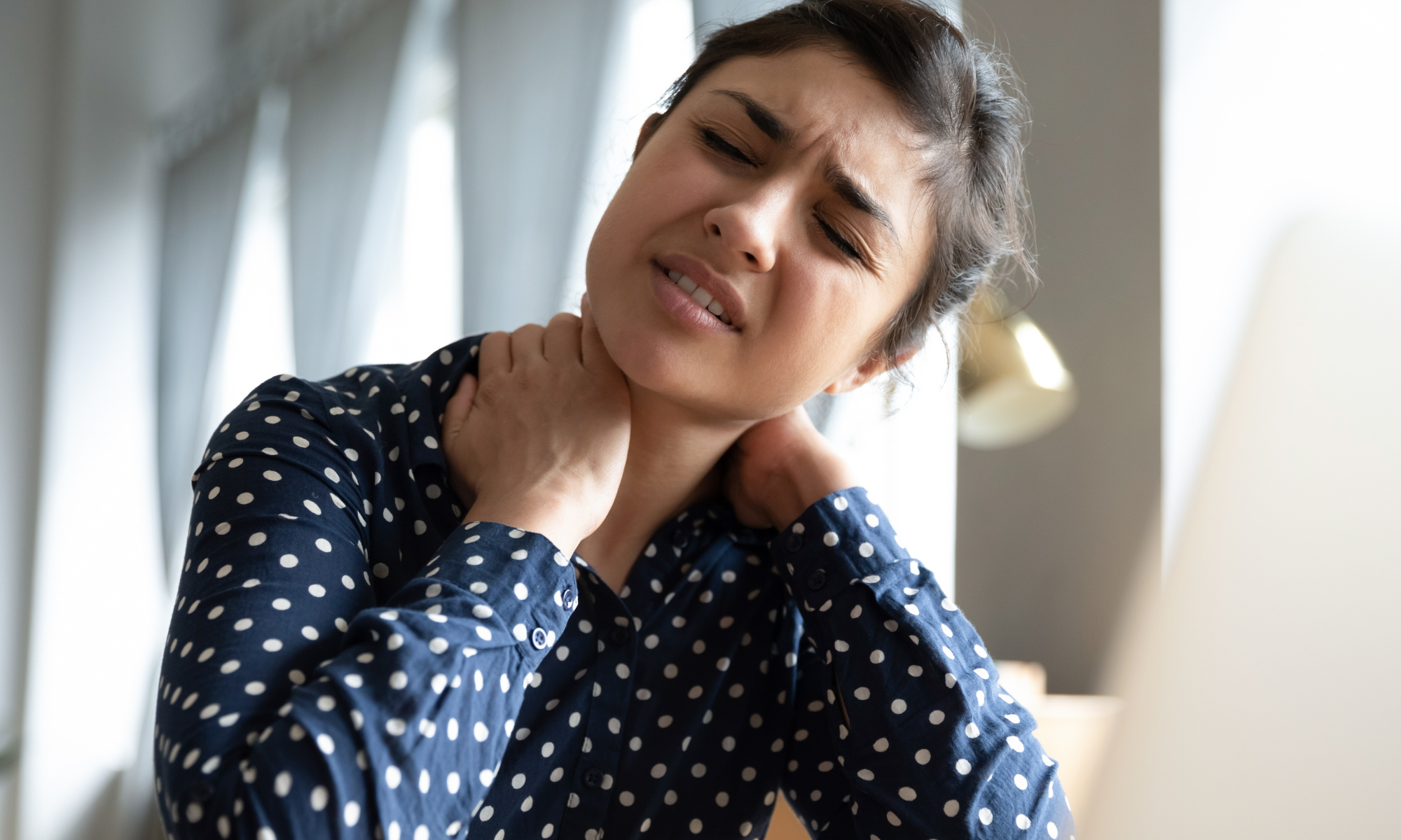 Woman rubs neck in discomfort Woman rubs neck in discomfort