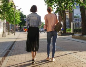 Two friends walking in an urban environment