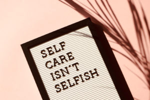 Small board with the words, "Self Care Isn't Selfish"
