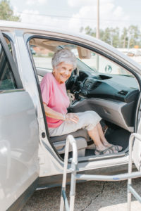 Senior woman prepares to get out of car and use walker