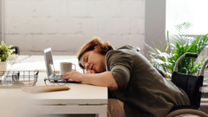Woman asleep on keyboard at her desk