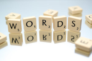 Scrabble tiles on a mirrored surface spell out the word, "WORDS"